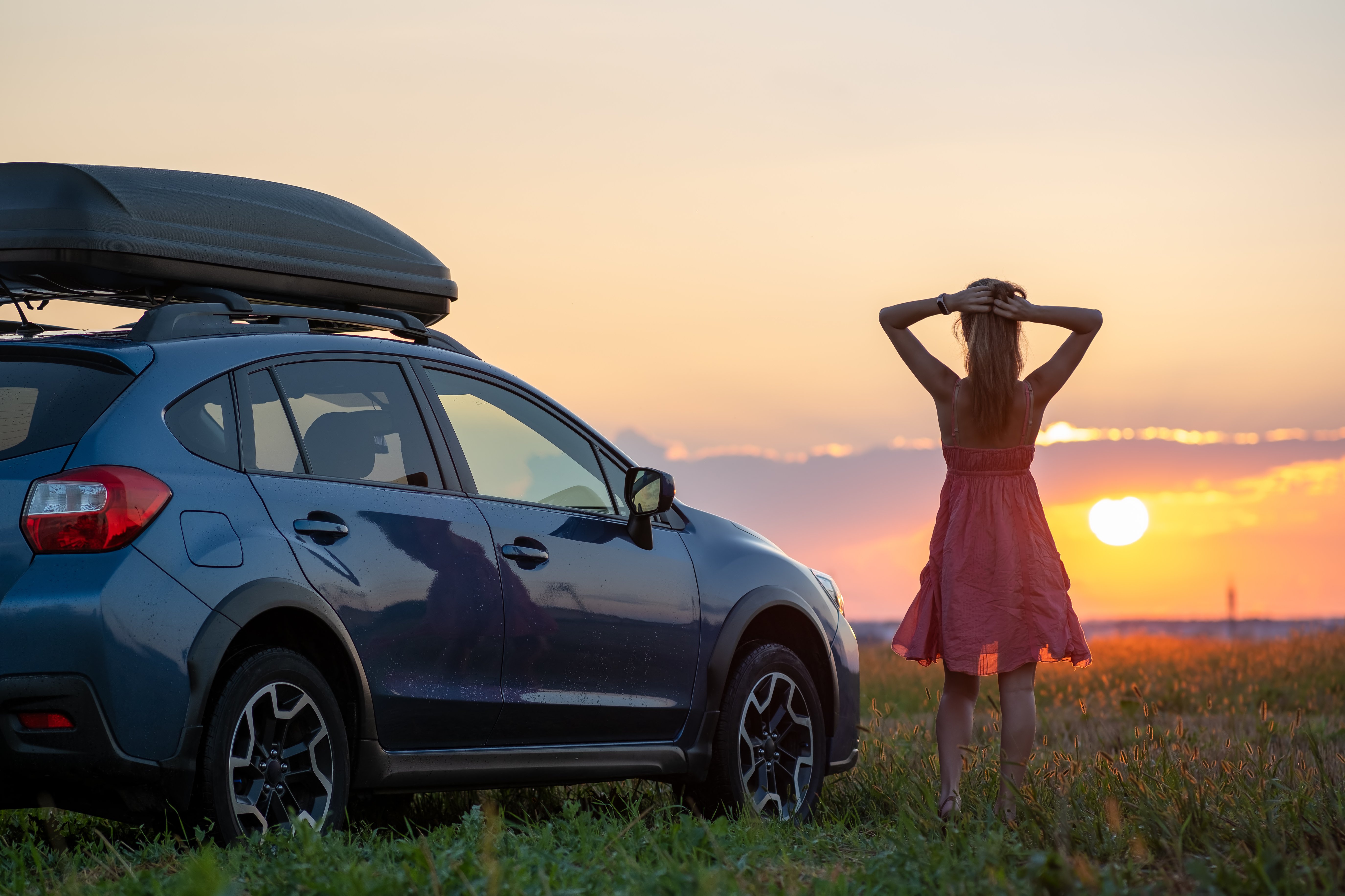 silhouette-female-driver-standing-near-her-car-grassy-field-enjoying-view-bright-sunset