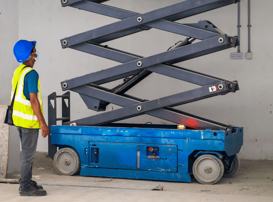 Manual Workers standing at the construction site next to the scissor lift