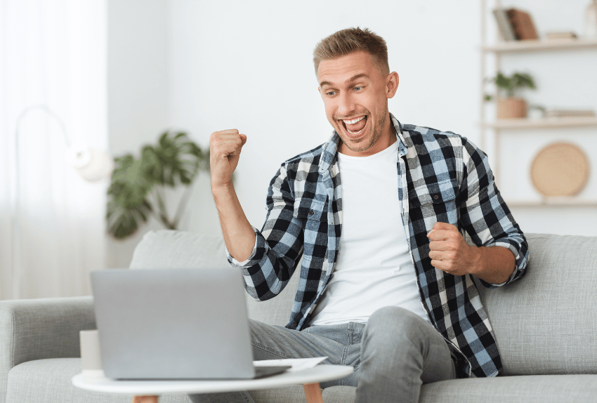 car loan calculator happy man seeing his results on his laptop