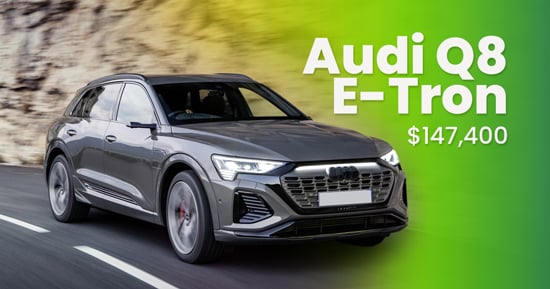 audi q8 e-tron on a road with its price and its name written on the sky