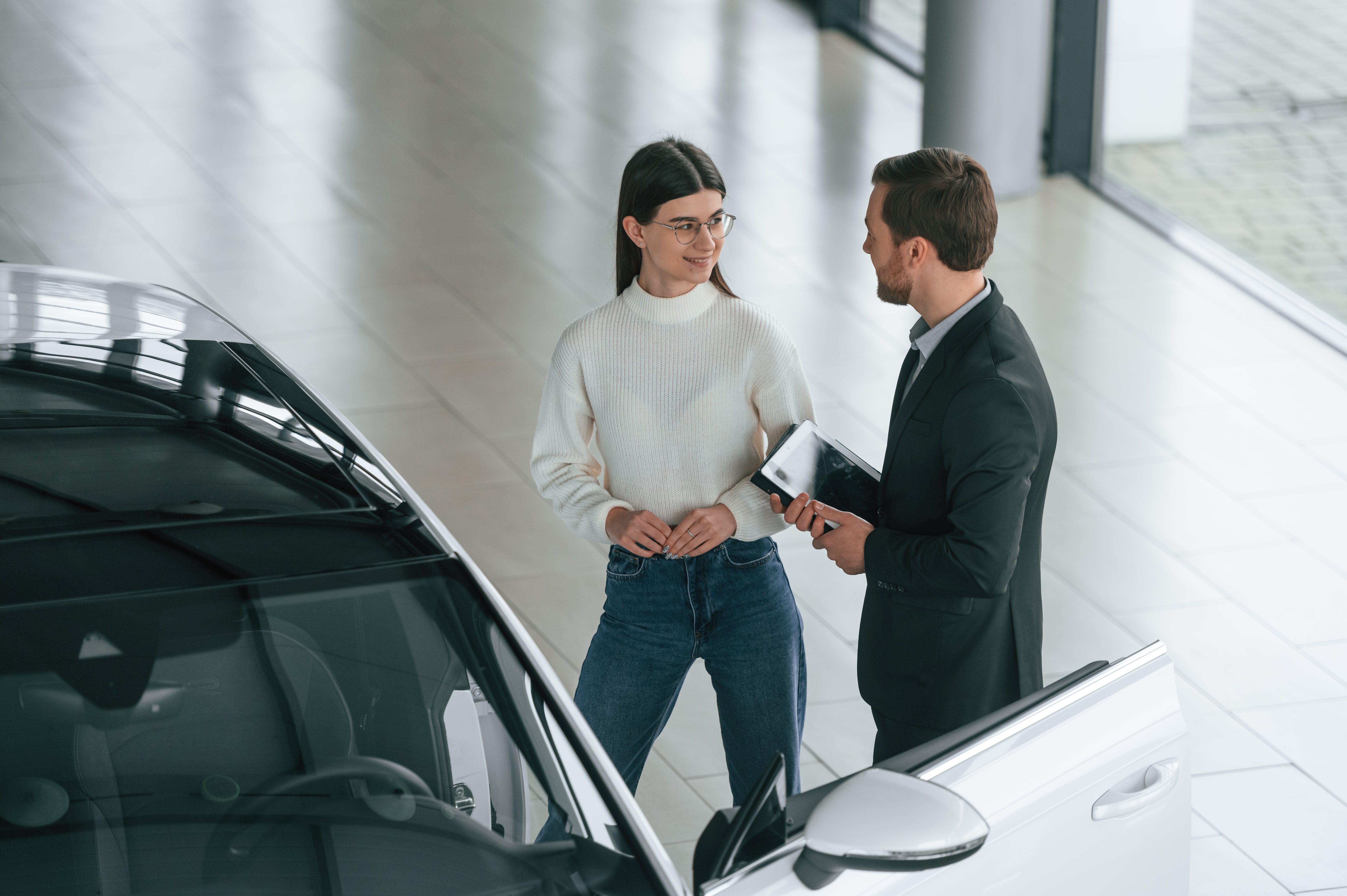talking-holding-tablet-man-is-showing-new-automobile-woman-customer-car-dealership