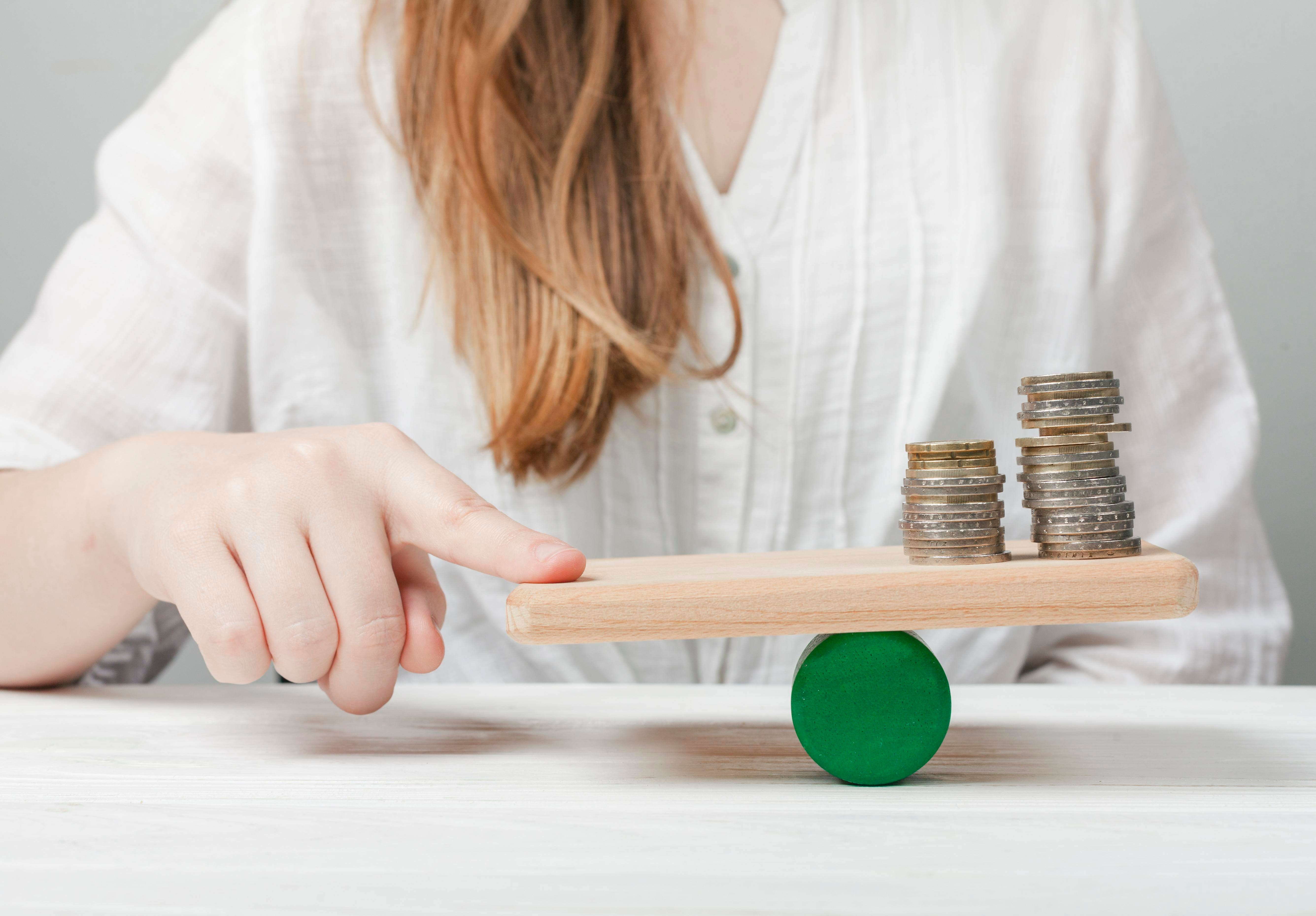 woman-holding-her-finger-balance-with-coins